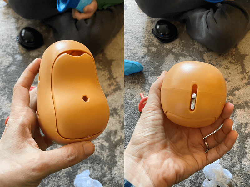 Orange plastic toy held in hand.